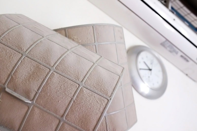 Dirty air filters in front of a clock.