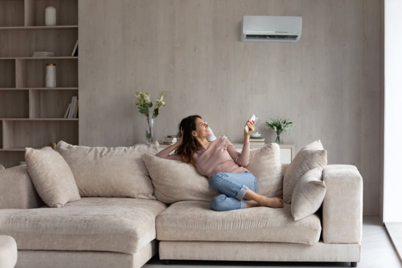 Planning to Remodel? Go Ductless! Relaxed young hispanic female homeowner sitting on huge comfortable couch