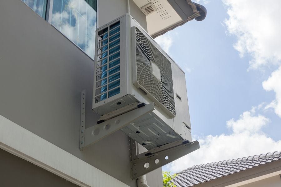 Outdoor heat pump mounted to exterior of home in Boca Raton