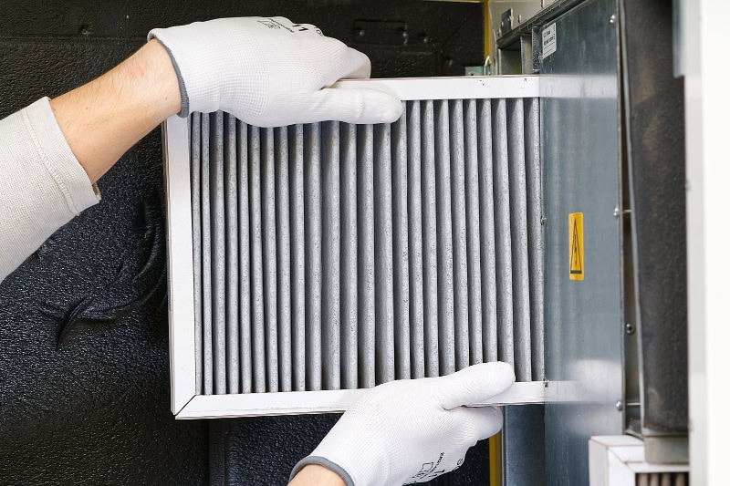 HVAC technician replacing a furnace filter in Boca Raton